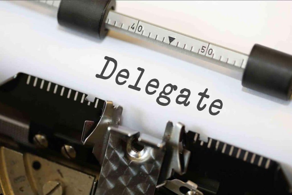 typewriter with the word delegate in the paper.