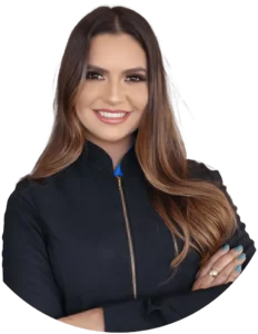 Woman with a blue sweater and standing up , smiling with crossed arms.